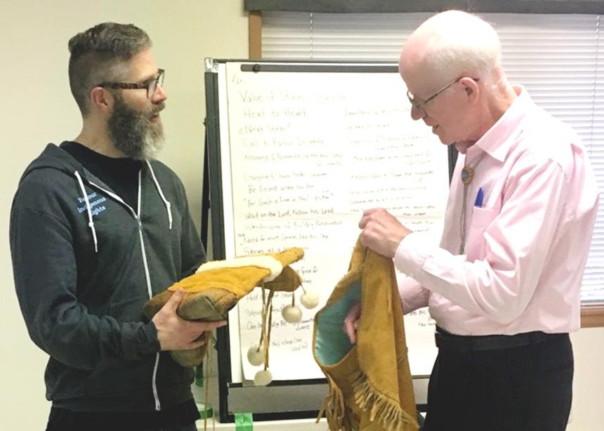 In this 2018 photo, Lorne Brandt (right), then chair of Mennonite Church B.C.’s Service, Peace and Justice Committee, presents Steve Heinrichs with a vest and moccasins made by Cree craftspeople. The governing body of Mennonite Church Canada has ended the full-time Indigenous-Settler Relations position that Heinrichs held for the last decade