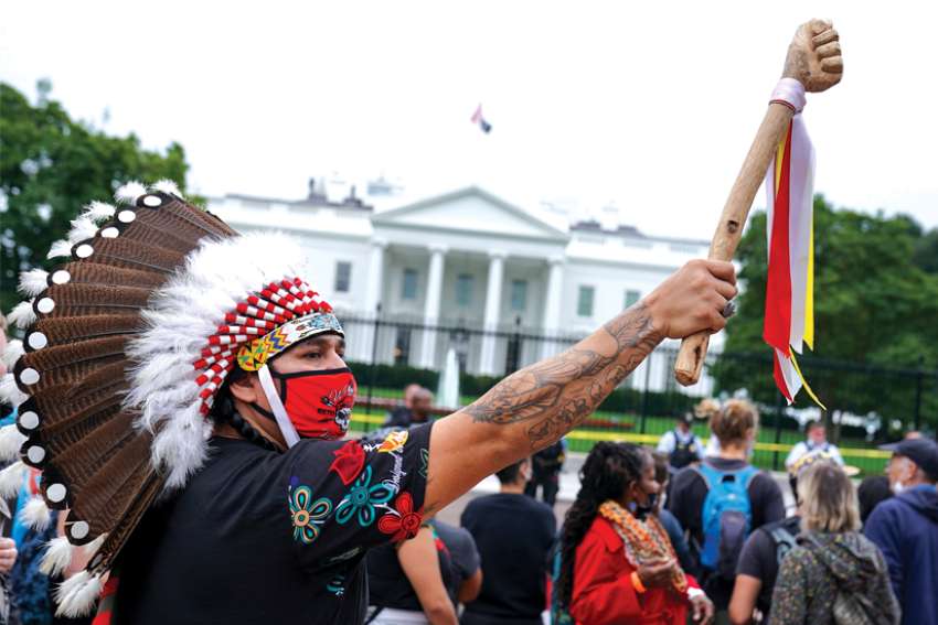 	 A demonstrator in Washington wears a traditional Native American headdress during an Indigenous Peoples’ Day protest outside the White House