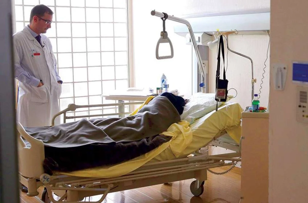 A doctor visits a patient in the palliative care unit of a hospital