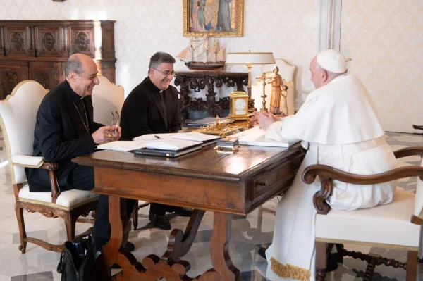 Pope Francis shares a laugh with Cardinal Víctor Manuel Fernández, right, prefect of the Dicastery for the Doctrine of the Faith, and Msgr. Armando Matteo, secretary of the dicastery's doctrinal section, during a meeting in the library of the Apostolic Palace at the Vatican