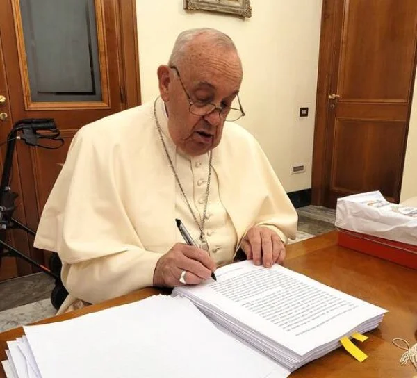 Pope Francis reviews and initials each page of the manuscript of 