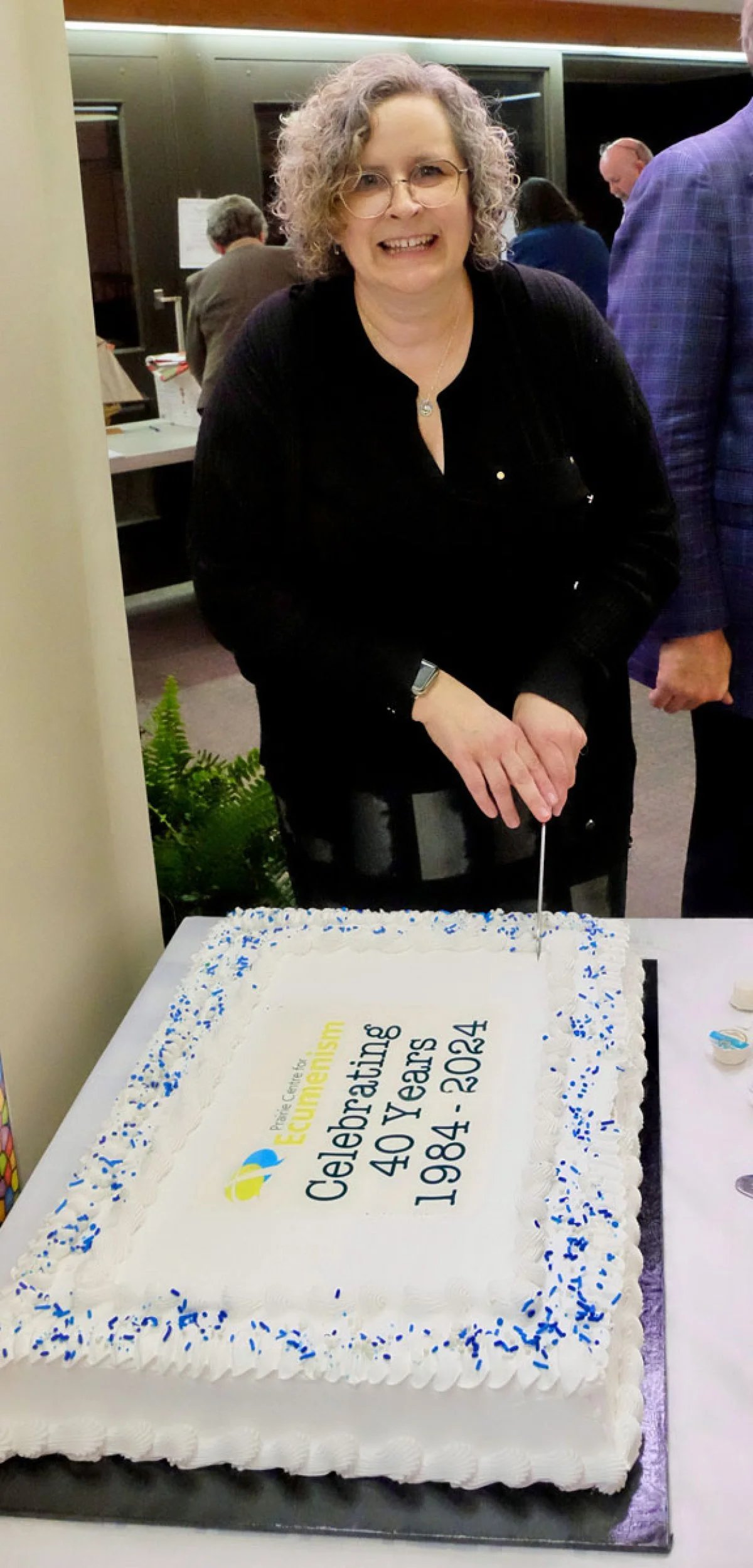 Director of the Prairie Centre for Ecumenism, Cathryn Wood, cuts the cake during the 40th anniversary celebration