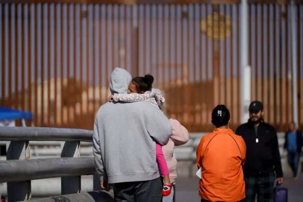 Cuban migrant Marielis Arosh and her family walk with other migrants after their CBP One app asylum appointment was cancelled on the day of U.S. President Donald Trump's inauguration, near the border fence in Mexicali, Mexico