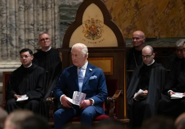 King Charles III seated in the Basilica of St. Paul Outside the Walls after he was granted the title 'Royal Confrater.' His chair, with the royal coat of arms and the motto 'Ut Unum Sint,' will remain in the sanctuary