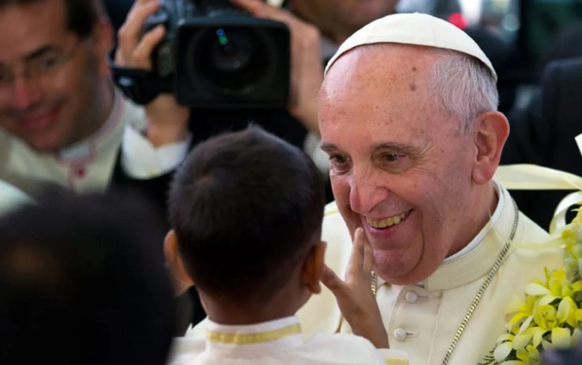 Pope Francis smiled after getting a garland from a child as he arrived for an interfaith meeting in Colombo, Sri Lanka, Tuesday