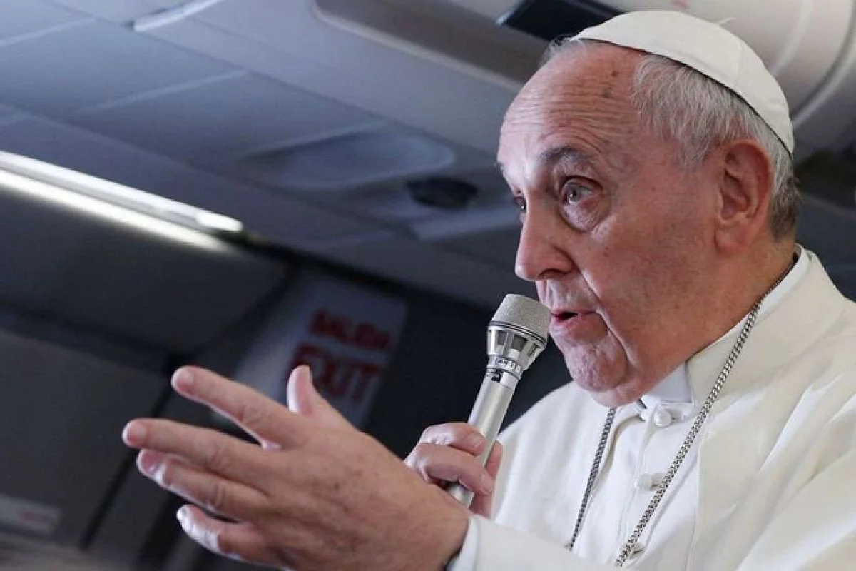 Pope Francis answering questions from the press corps