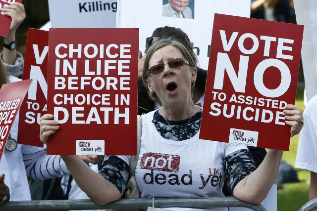 A demonstrator against assisted suicide joins a protest outside the Houses of Parliament in London, England last September