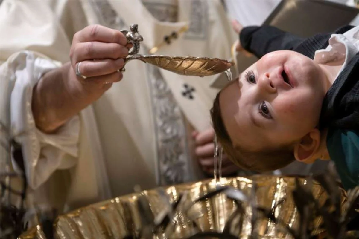 Pope Francis baptizes a baby as he celebrates Mass on the feast of the Baptism of the Lord in the Sistine Chapel at the Vatican