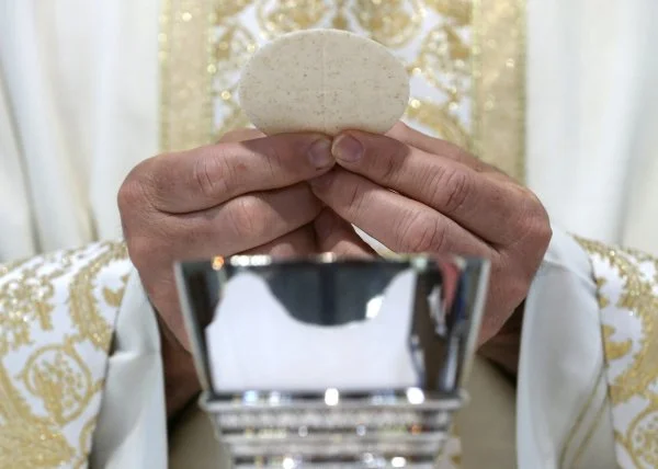 A priest holds the Eucharist in this illustration taken May 27, 2021. The 