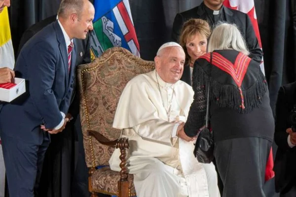 Pope Francis is greeted by a Métis representative during the formal arrival ceremony at the Edmonton airport