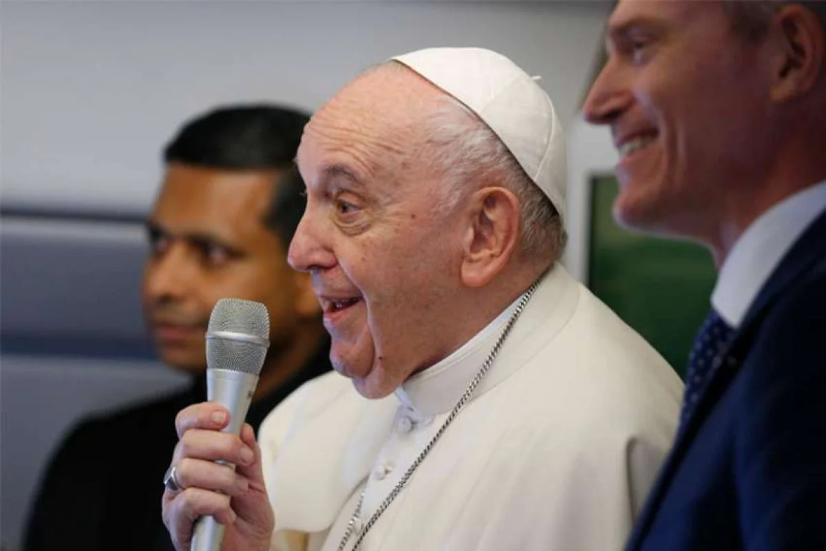 Pope Francis greets journalists aboard his flight from Rome to Edmonton, Alberta