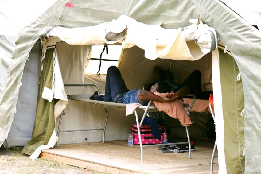 A refugee rests in a tent set up by the Canadian Armed Forces near the U.S.-Canadian border in Lacolle, Quebec
