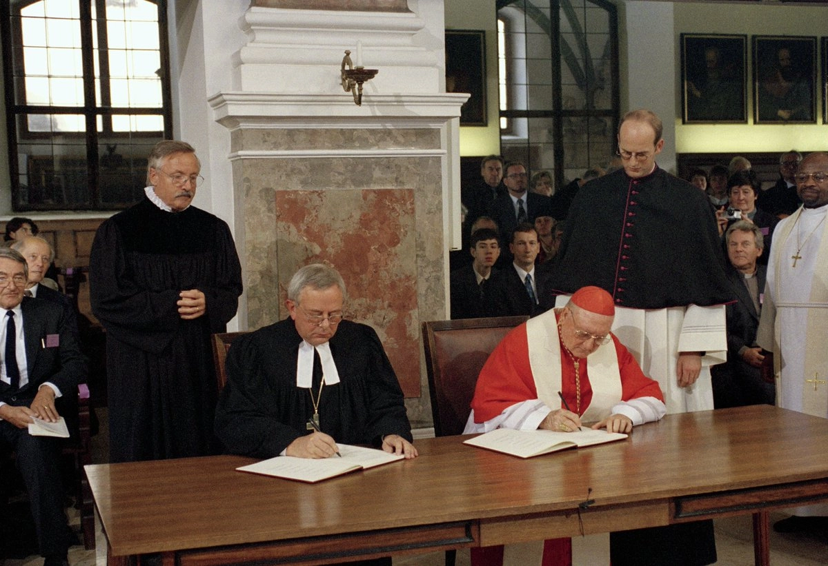 The Presidents of the Lutheran World Federation, Christian Krause, and the Pontifical Council for Promoting Christian Unity, Cardinal Edward Idris Cassidy, sign the Joint Declaration on the Doctrine of Justification at St Anna’s Lutheran Church in Augsburg, Germany, on 31 October 1999. The document has since been adopted or affirmed by the World Methodist Council, the World Communion of Reformed Churches, and the Anglican Consultative Council