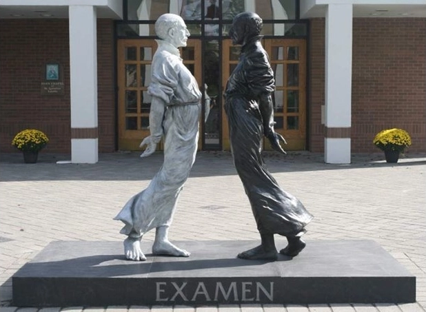 Examen, a sculpture depicting St. Ignatius of Loyola's central spiritual practice of examination of conscience. The sculpture stands in front of the chapel at the Jesuit's Fairfield University, Connecticut