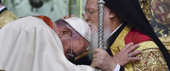 In this photo provided by Vatican newspaper L'Osservatore Romano, Patriarch Bartholomew I, right, kisses Pope Francis' head during an ecumenical service at the Patriarchal Church of St. George in Istanbul, Saturday, November 29, 2014
