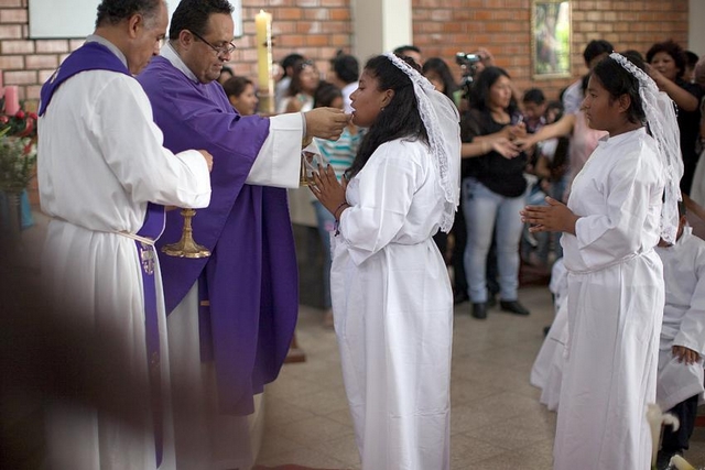 Lutheran pastor Rev. Pedro Bullón (left) and Catholic priest Fr. Marco Agüero Vidal (right) preside at the joint First Communion in Pamplona Alta, Lima, December 2014. Photo: LWF/Sean Hawkey