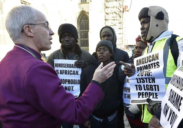 Anglican Archbishop Justin Welby of Canterbury, spiritual leader of the Anglican Communion, speaks with protesters on the grounds of England’s Canterbury Cathedral, which was closed for a meeting of Primates of the Anglican Communion