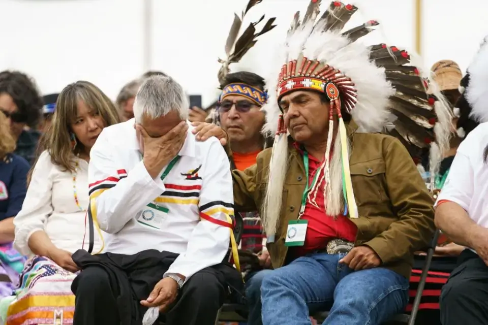 A man is comforted by an Indigenous leader during ceremonies in Maskwacis, Alberta, where Pope Francis apologized to Canada's native people on their land for the church's role in schools where Indigenous children were abused