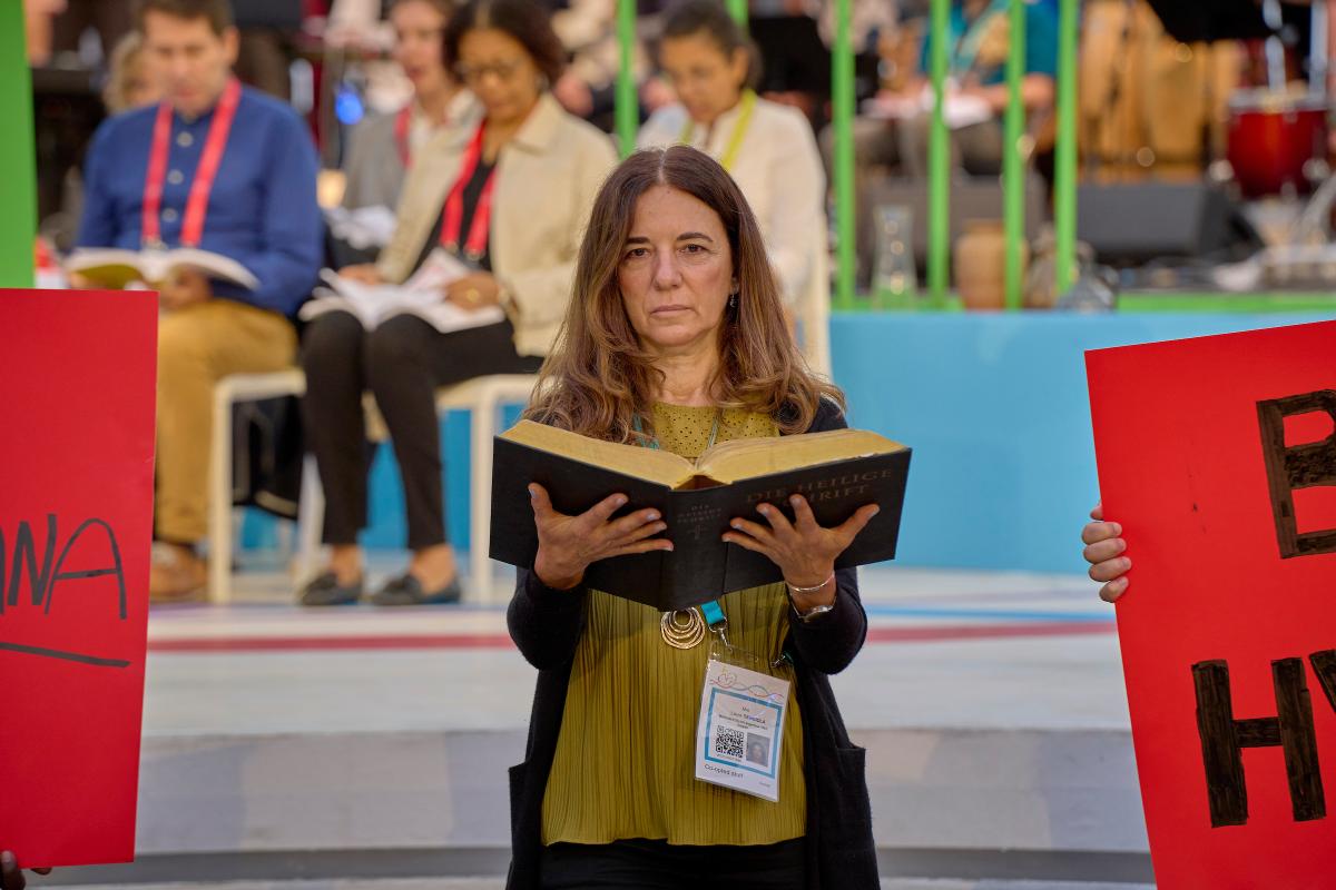 A woman holds a Bible during the morning prayer service at the World Council of Churches' 11th Assembly in Karlsruhe, Germany. The Assembly's theme is 'Christ's Love Moves the World to Reconciliation and Unity'