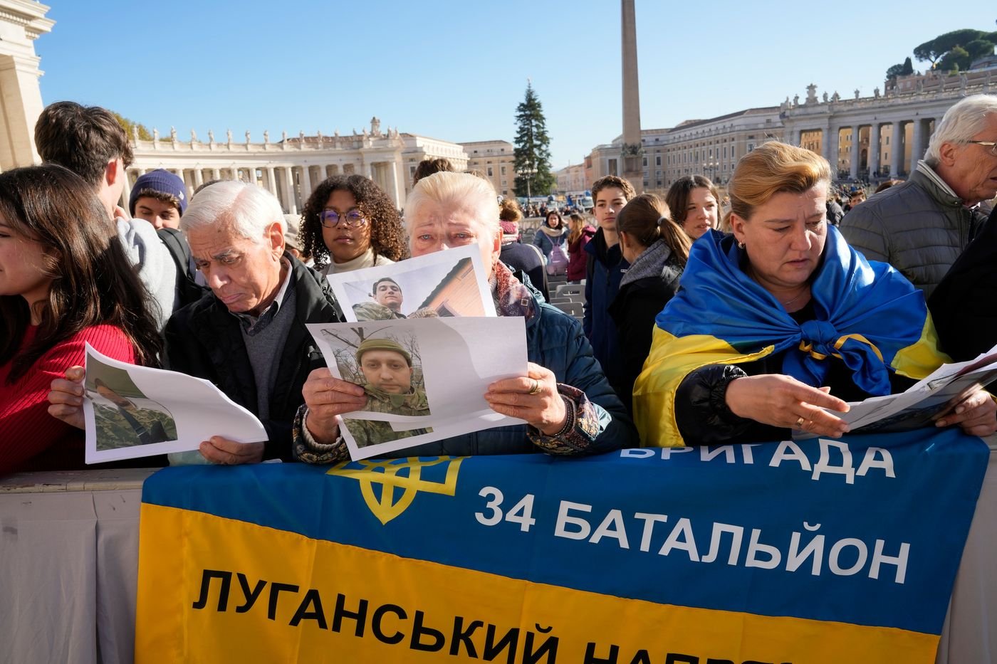 Ukrainians, with photos of missing soldiers, wait for Pope Francis to arrive in St. Peter's Square for the Wednesday audience