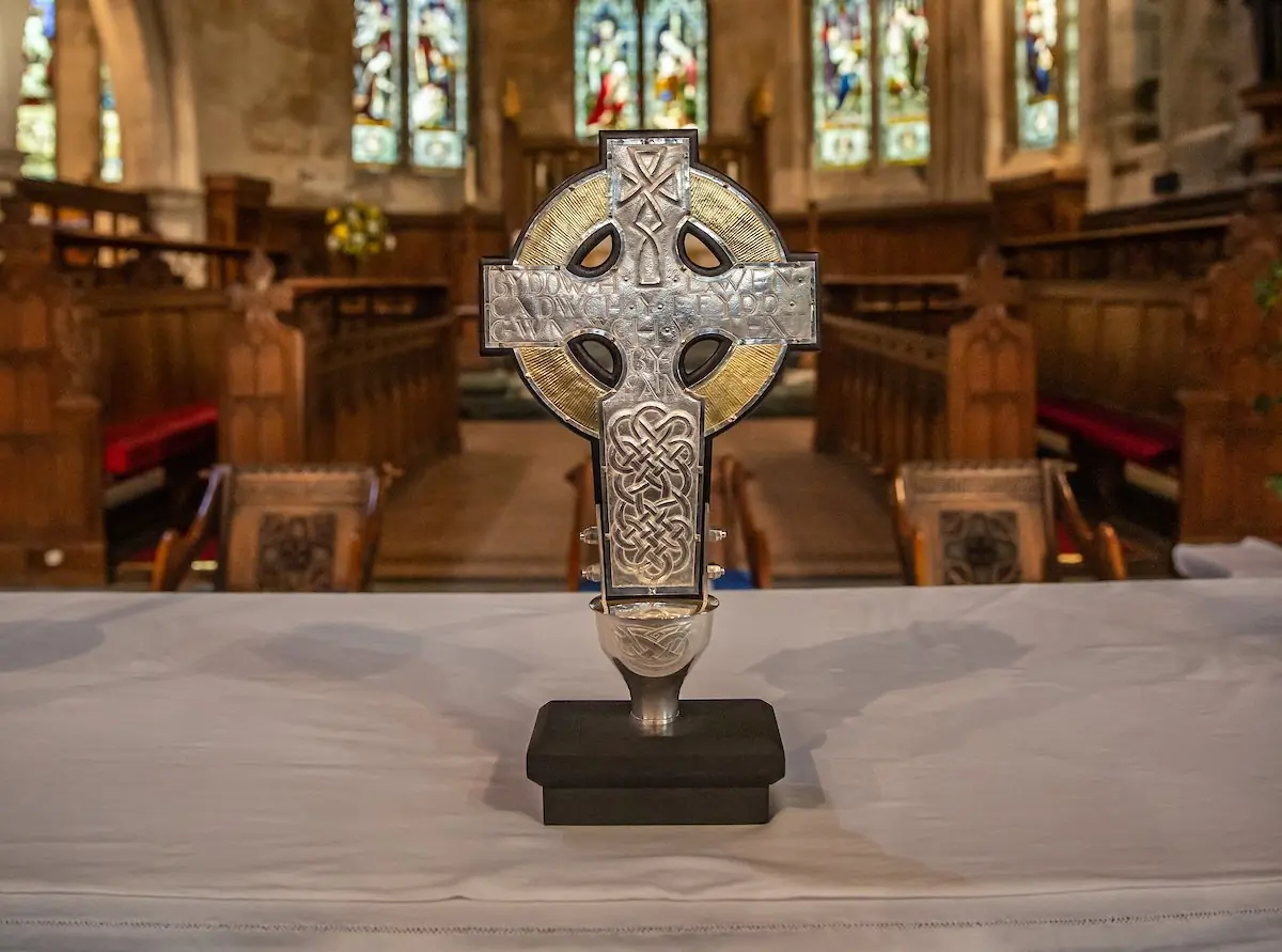 The back of the Cross of Wales is inscribed with words from the final sermon of St David, 'Byddwch lawen. Cadwch y ffydd. Gwnewch y Pethau Bychain,' which means in English, 'Be joyful. Keep the faith. Do the little things.' The Cross includes a relic of the True Cross, gifted to King Charles III by Pope Francis. The Cross will be used during the Coronation on May 6