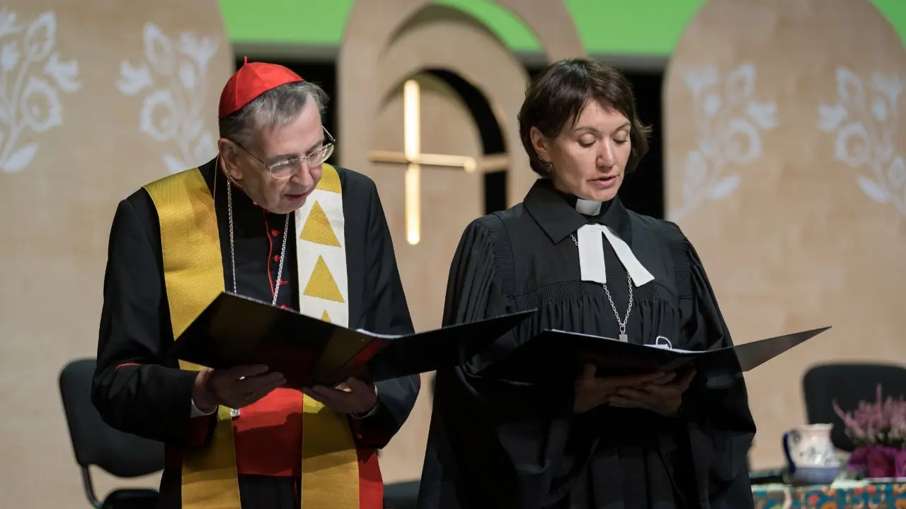 Cardinal Kurt Koch, prefect of the Vatican Dicastery for Promoting Christian Unity, and the Rev. Anne Burghardt, general secretary of the Lutheran World Federation, pray during an ecumenical service at the LWF assembly in Krakow, Poland