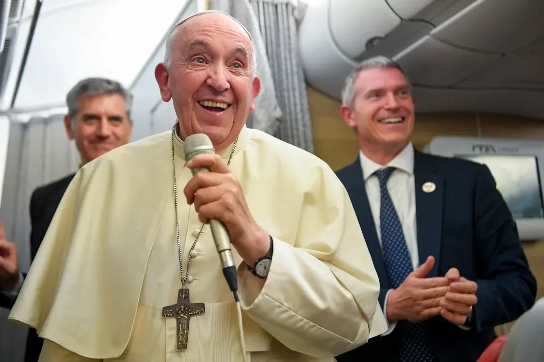 Pope Francis smiles as he answers questions from journalists aboard his flight from Iqaluit, Nunavut, to Rome