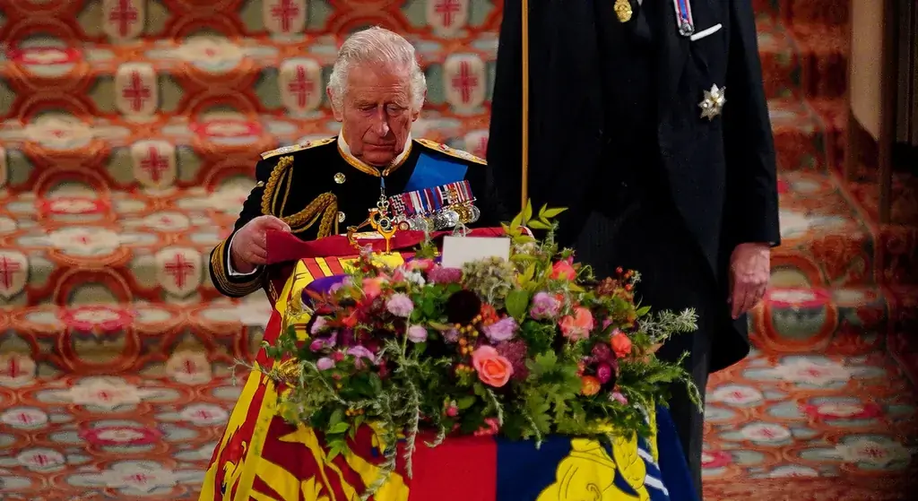 King Charles III places the Queen’s Company Camp Colour of the Grenadier Guards on the coffin of Queen Elizabeth II, one of the final acts of the committal service of the queen, held at St. George’s Chapel in Windsor Castle
